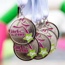 Grouping of five Girls on the Run 5K medals 